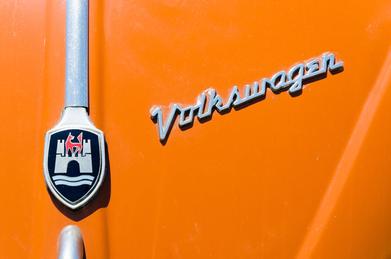 O logo da Volkswagen e da cidade de Wolfsburgo, terra da marca alemã, no capô de um Fusca.